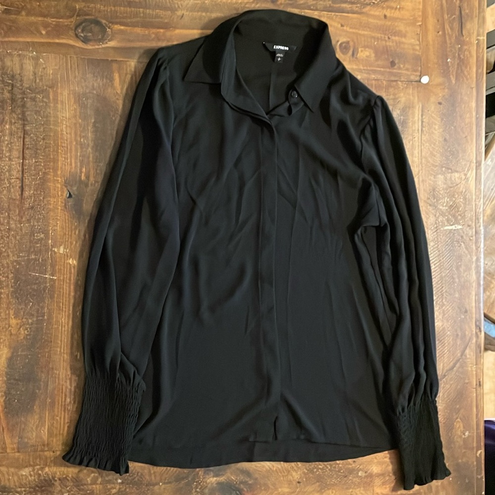 A black barley used express blouse with ruffle cuffs